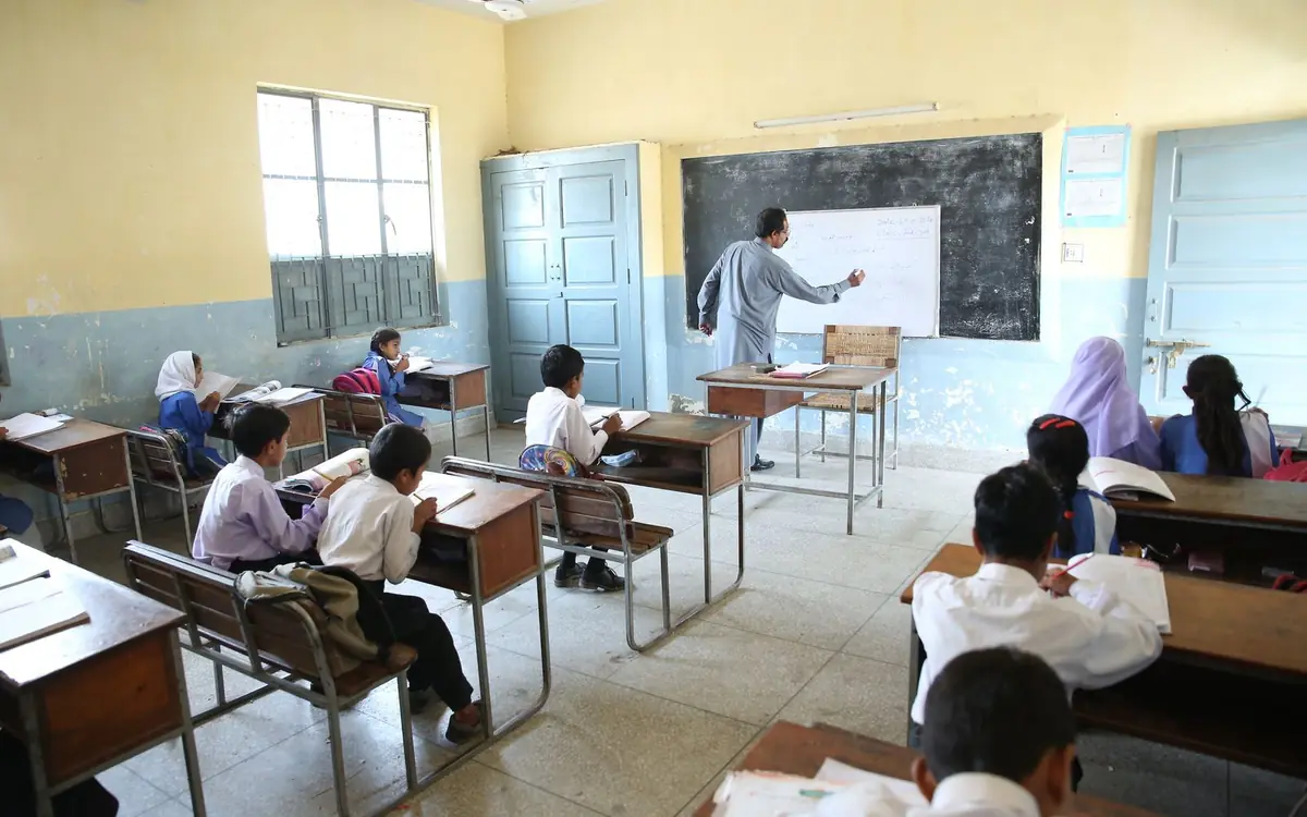 School Trips Primary school classroom with a teacher at the blackboard and students at desks