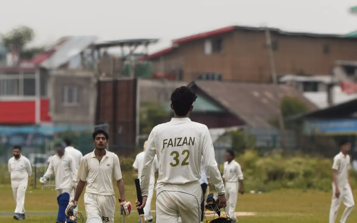 Sports Events Cricketers in white uniforms walking off the ground after a match